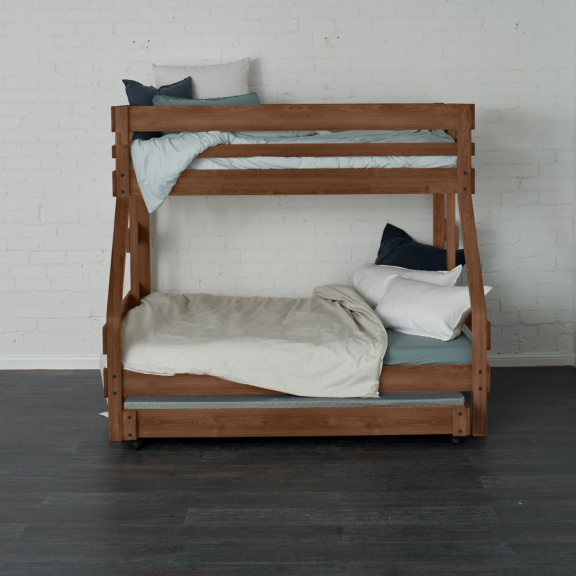 Native elm single over double bunk bed with ladder and neutral bedding against white brick wall.