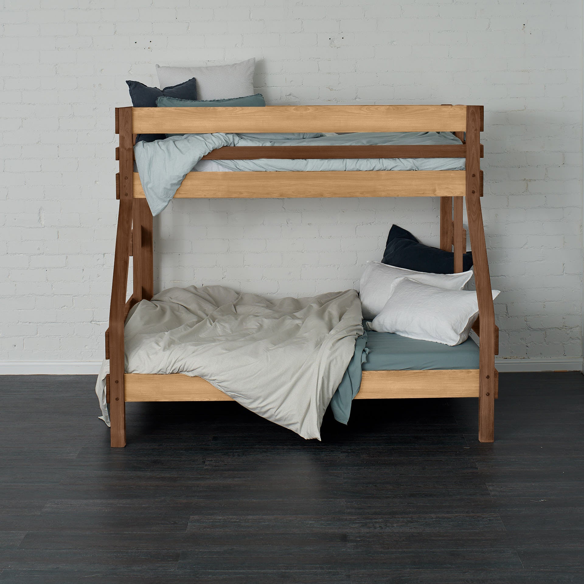 Native elm single over double bunk bed with ladder, soft grey bedding, and pillows.