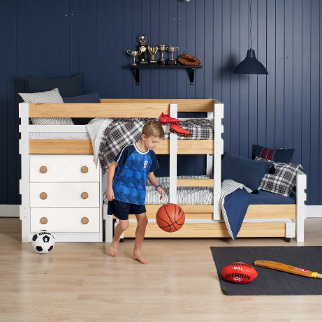 Low height long-wall bunk bed in white with natural elm accents, integrated chest drawers, and pull-out lower bed.