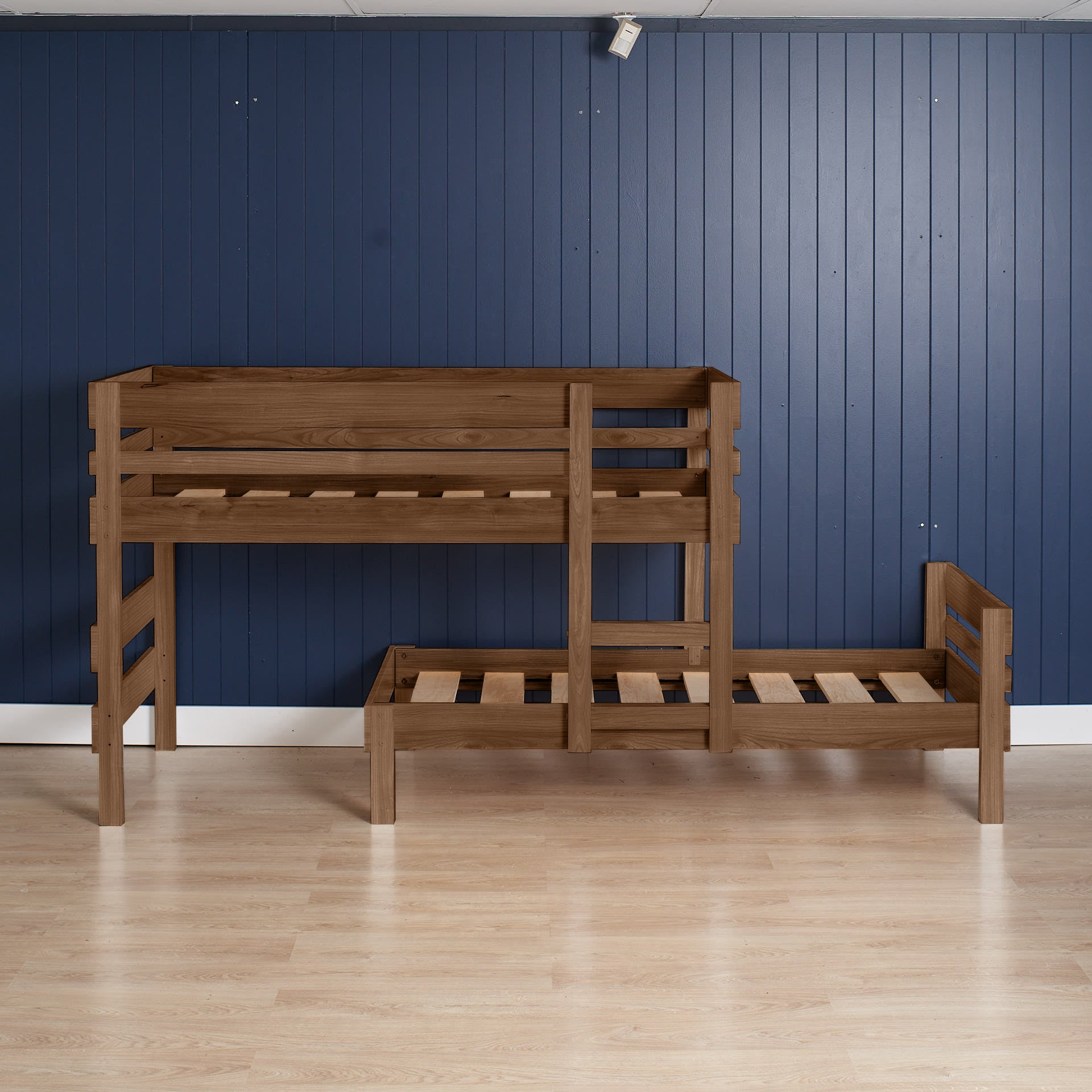 Native Elm low height long-wall bunk bed with ladder and slatted frames against blue paneled wall.