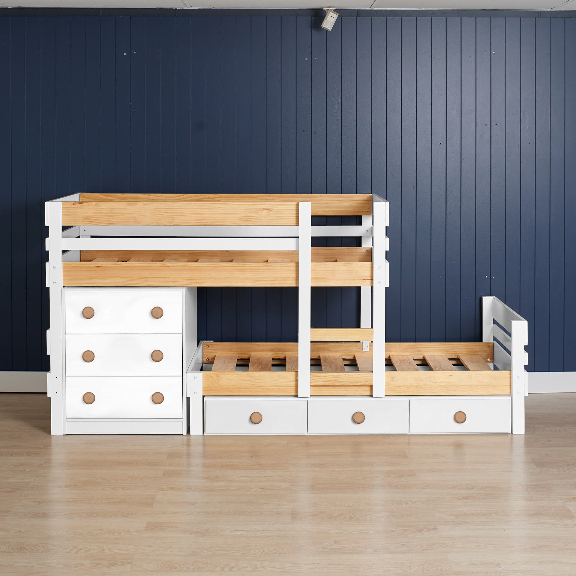 Low height long-wall bunk bed in white and native elm wood with built-in drawers and open slatted design.