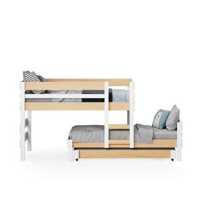 Low height long-wall bunk bed in white and natural wood with side ladder and pull-out trundle bed.