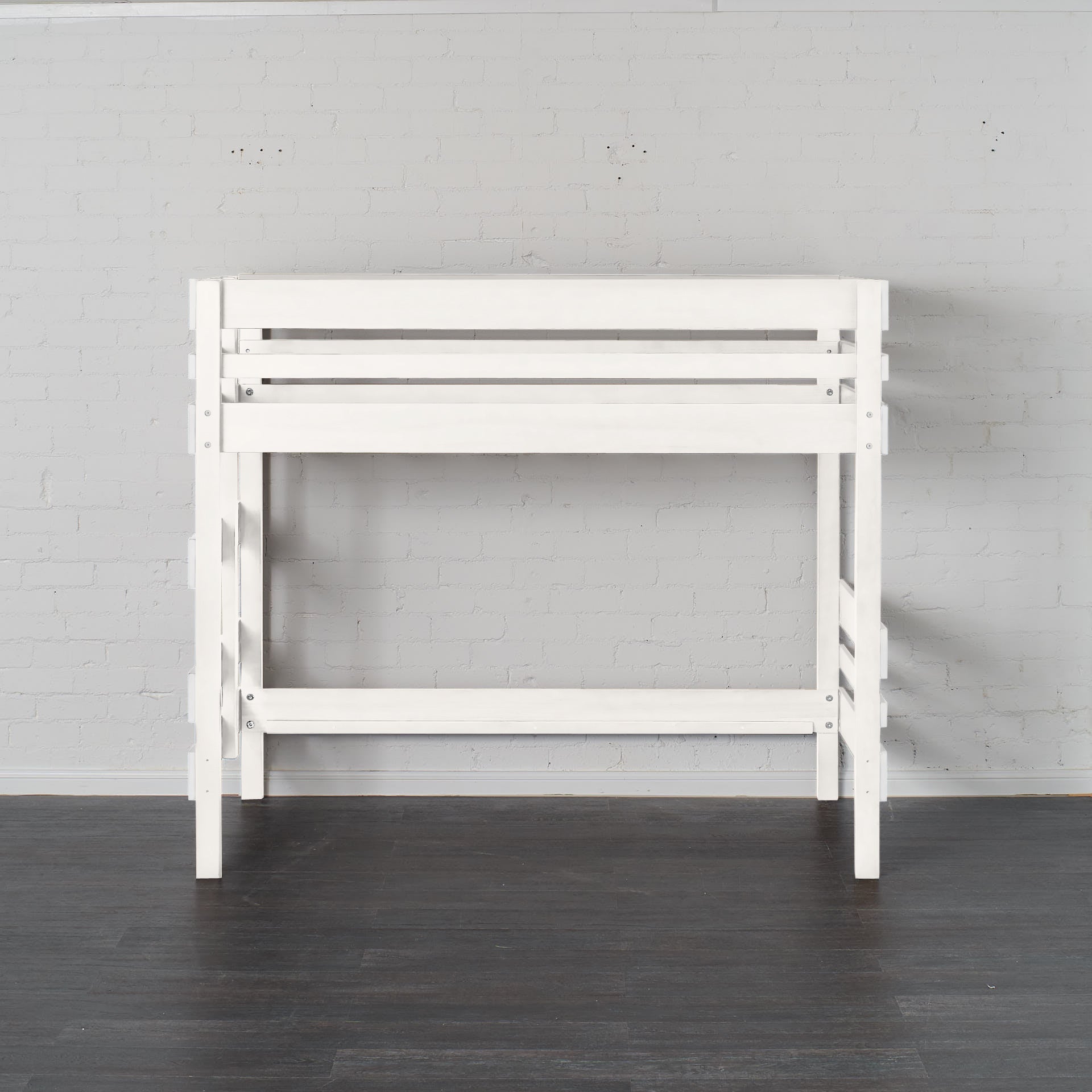 White mid height high bed frame with slatted guardrails and sturdy legs against light wall.