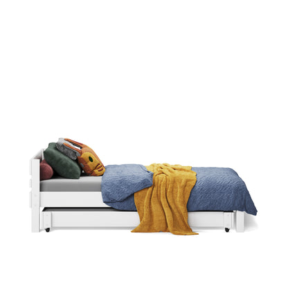 White single bed with simple panel headboard, blue and mustard bedding, and colorful pillows.