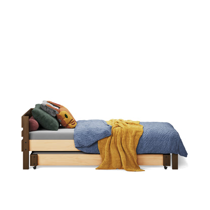 White single bed with wooden frame, blue blanket, mustard throw, and multiple pillows.