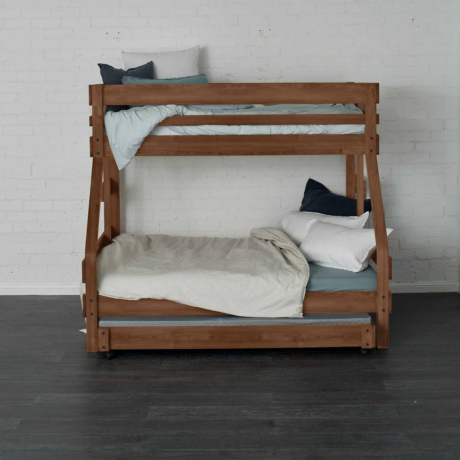 Native elm single over double bunk bed with ladder and neutral bedding against white brick wall.
