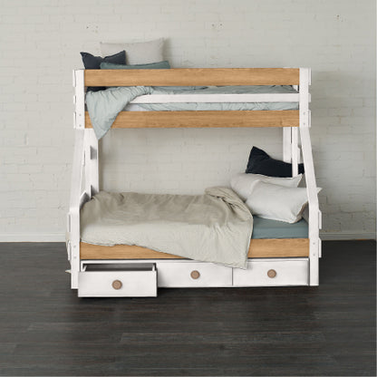 White and natural wood single over double bunk bed with under bed drawers and neutral bedding.