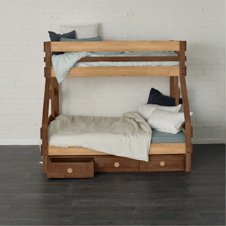 Native elm single over double bunk bed with under bed drawers and minimalist bedding.