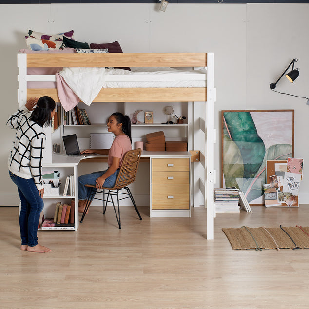 Double loft bed sits above L shaped desk study with storage
