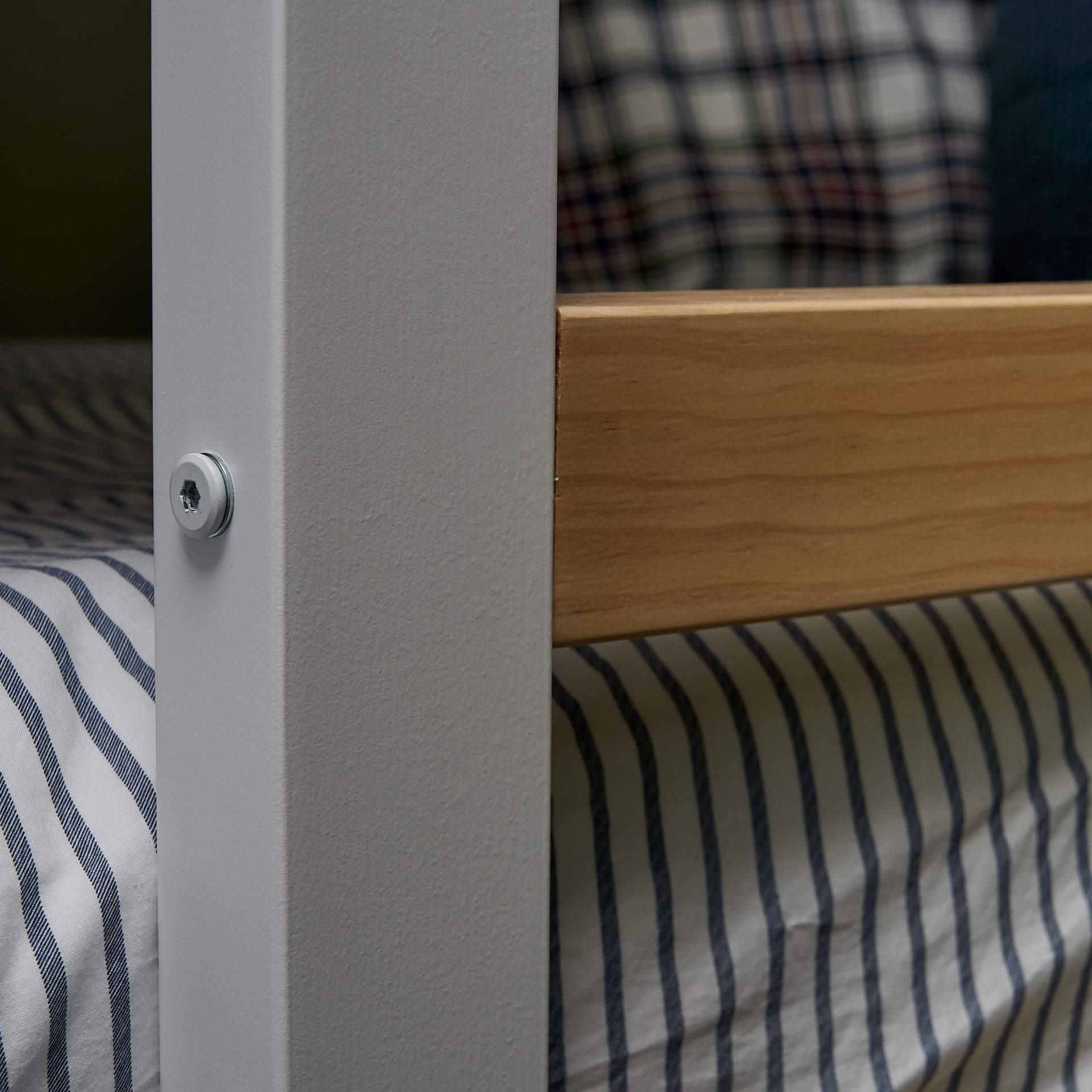 Bunk bed ladder fixing close up. Clear pine timber rung on white. Side ladder access bunk.